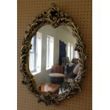 An ornate oval gilt framed mirror. 61 x 45cm.