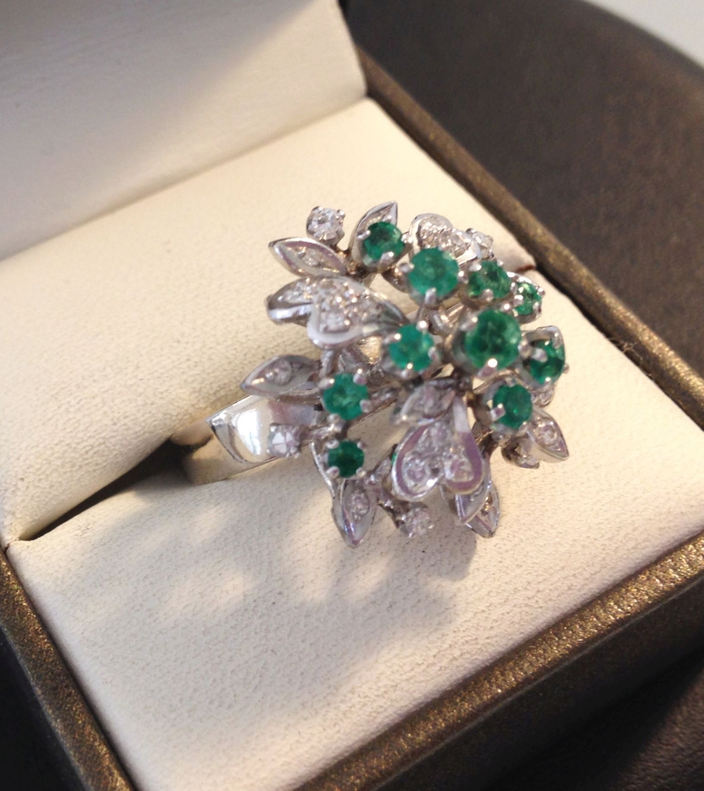 A 14ct white gold diamond & emerald cluster ring set with 22 diamonds and 10 emeralds - size O.