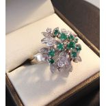 A 14ct white gold diamond & emerald cluster ring set with 22 diamonds and 10 emeralds - size O.
