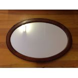 An oval mirror with gadrooned frame.