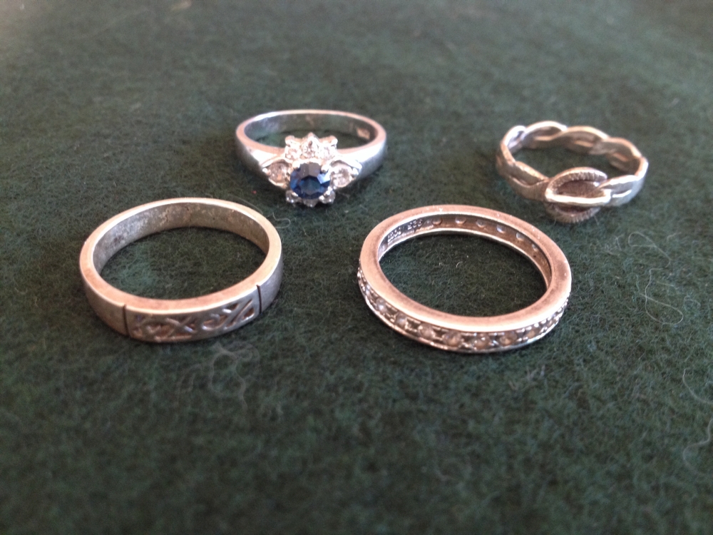 4 silver ladies rings to include an eternity ring.