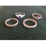 4 silver ladies rings to include an eternity ring.