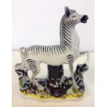 19th century Staffordshire zebra. Some restoration. 26cm tall.