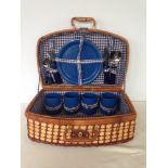 A vintage picnic hamper with plates, cups & cutlery.