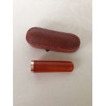 An amber cigar/cheroot holder with gold rim in fitted case. Tests as at least 9ct gold - no