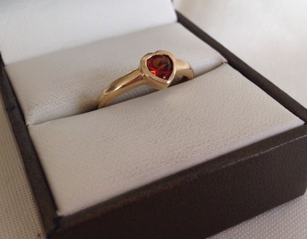 9ct gold ring with central heart shaped garnet. Size N.