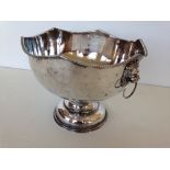 A silver plated on copper punch bowl with lion head handles.