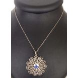 A filigree silver flower design pendant with a ceramic centre depicting a Dutch Delft windmill,