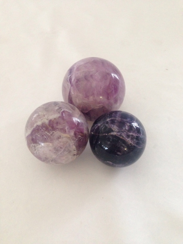 Three polished rock crystal balls.