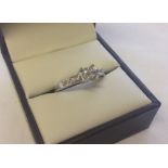 An 18ct white gold diamond ring set with 4 square cut diamonds set in square mount with 4 round