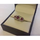An 18ct gold, ruby and diamond triple cluster ring, size N.