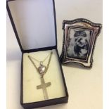 2 silver pendants on silver chains, one a heart shaped locket, the other a cross, together with a