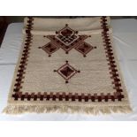 A hand made cream & brown wool rug, 115cm x 200cm.