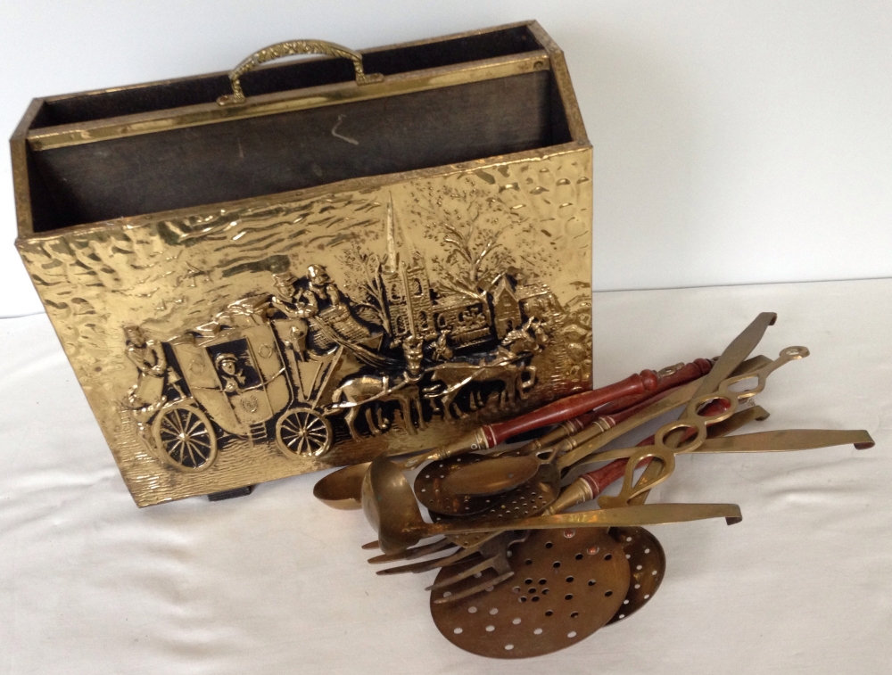 A brass magazine rack & assorted brass spoons and ladles.