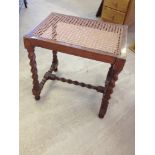 An antique oak rattan topped stool with barley twist legs.