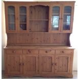 A large pine dresser with 4 door glass cupboard doors, 183cm long x 43cm deep x 198cm tall.