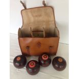 A set of 4 crown green bowls in leather carry case.