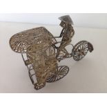 A vintage oriental white metal Rickshaw & driver.