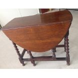 An oak gateleg table with barley twist legs.