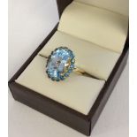 Ladies dress ring with large approx 4ct central blue topaz stone surrounded by 18 Swiss blue topaz