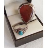 2 silver rings, 1 set with a large brown stone, Size K, the other set with a turquoise cabouchon,