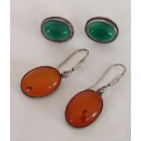 2 pairs of silver earrings, one set with amber cabouchon stones, the other set with green stones.