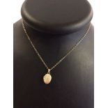 Small 9ct gold engraved oval locket on 16" gold chain. Locket measures approx 2cm to the top of