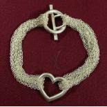 Silver T Bar bracelet with central open heart and chain detail. Marked 925.