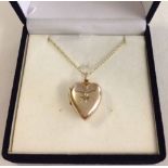 Gold heart shaped locket set with central diamond on 18" 9ct gold chain.  Locket tests as 15ct gold.