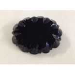 Antique oval Whitby jet brooch with carved sides and flat centre.  Approx 5.4cm across, no