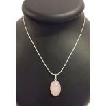 Rose quartz oval shaped pendant set in silver on a white metal chain marked 925.