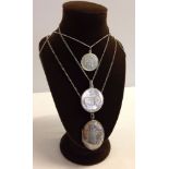 A collection of 3 silver pendants on chains to include an oval locket, a Royal commemorative