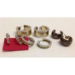 4 pairs of silver hoop earrings of various sizes and designs.
