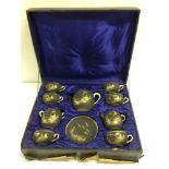 A late 19th/early 20th century boxed Japanese tea set. Black ground with gilt decoration and