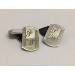 A pair of hallmarked silver cufflinks engraved with initials P.W.