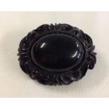 Carved and polished antique Whitby jet brooch with domed oval centre.  Approx 4cm across. Some