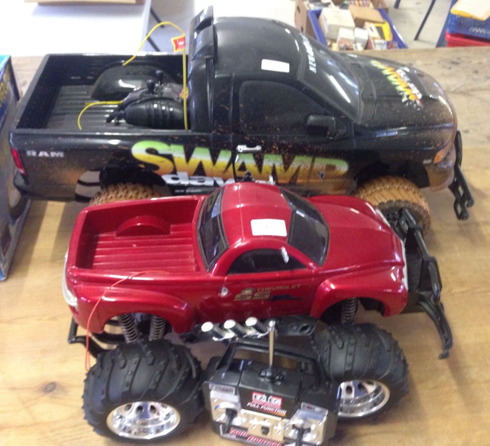 2 large radio controlled pick-up trucks. A black New Bright 'Swamp Dawg' and an EzTec red