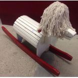 Vintage wooden rocking horse with mop head.