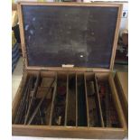 A wooden box of vintage 'Erector' Meccano style building pieces.