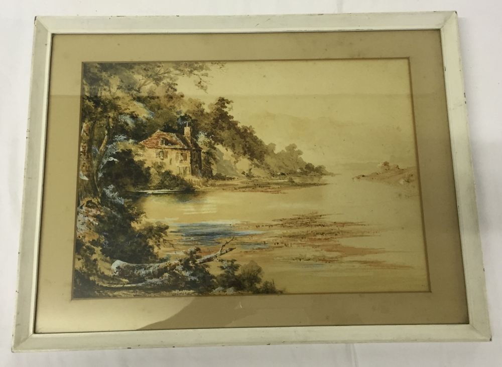 A framed & glazed watercolour of a cottage by a river. Unsigned. Frame size 34 x 45cm.