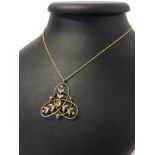 A Victorian gold pendant set with a central peridot and seed pearls on an 18 inch 9ct gold chain.