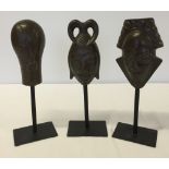 3 modern metal tribal heads on stands, approx 28cm tall.