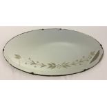 Vintage bevel edge oval mirror with floral decoration. Measures approx 27" wide.