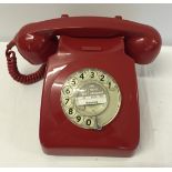 A vintage red GPO telephone with dial.