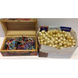 A box of faux pearl necklaces together with a wooden box of ethnic bead jewellery.