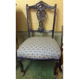 A Victorian nursing chair with fretwork back and china casters in blue & gold upholstery.