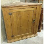 A pine corner cabinet approx 62cm wide (wallside), 85cm across front and 86cm tall.