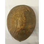 A carved shell, possibly coconut with parrot decoration.