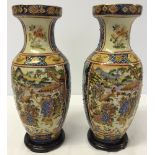A pair of decorative oriental Satsuma Pottery vases on wooden coasters. Aprox 13"/33cm tall.