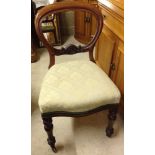 A Victorian balloon back chair with pale green & gold upholstery, turned legs and china casters.